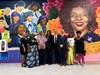A group of people pose in front of a mural at the Elizabeth Duff Transit Center at WeGo Central